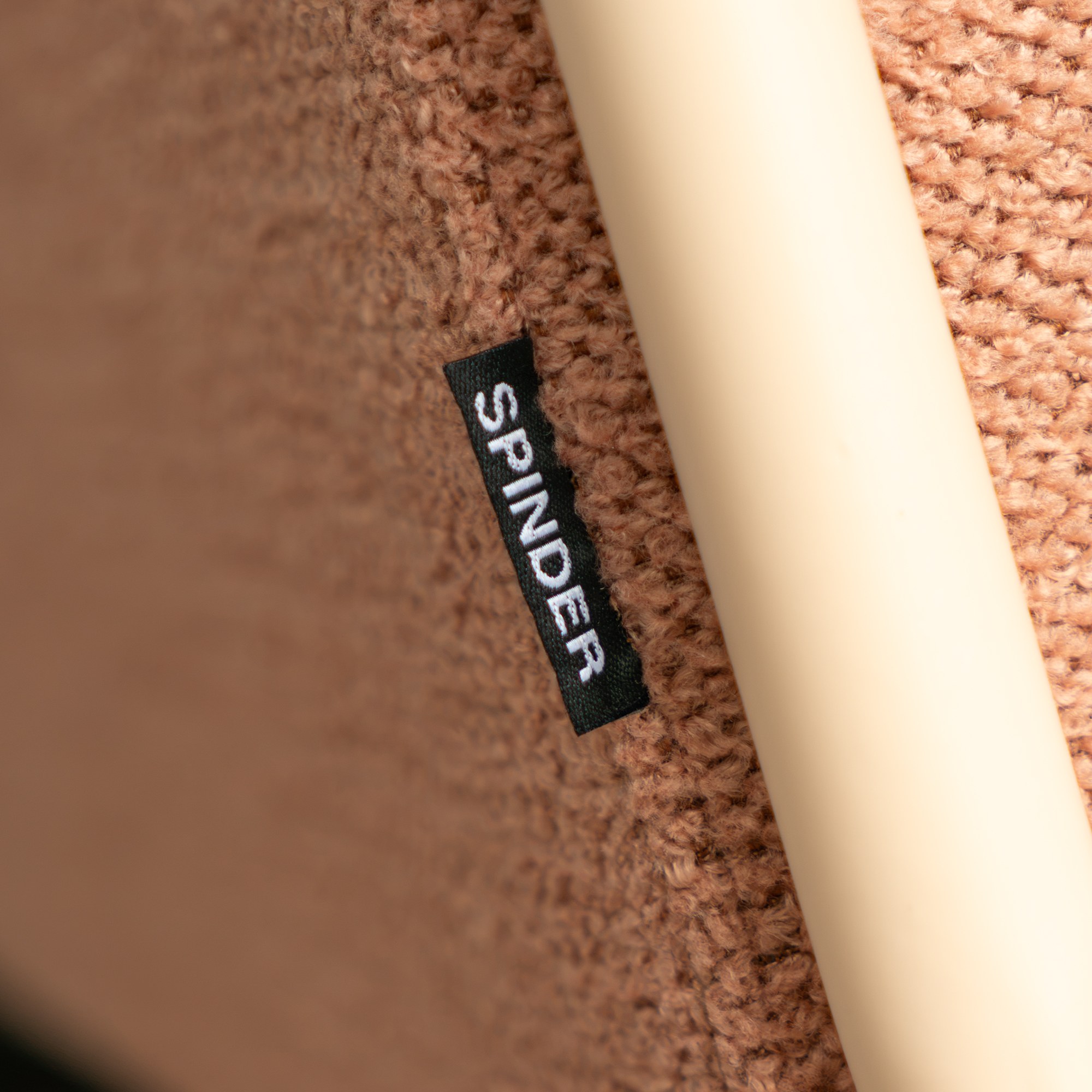Spinder Design Retro Sessel Peachy Rosé / Blush Bouclé – Detailaufnahme Spinder-Label am Bezug
