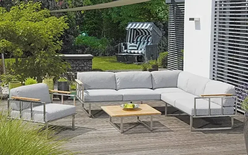 Helle Gartenlounge mit niedrigem Tisch auf einer Holzterrasse im Grünen – SonnenPartner