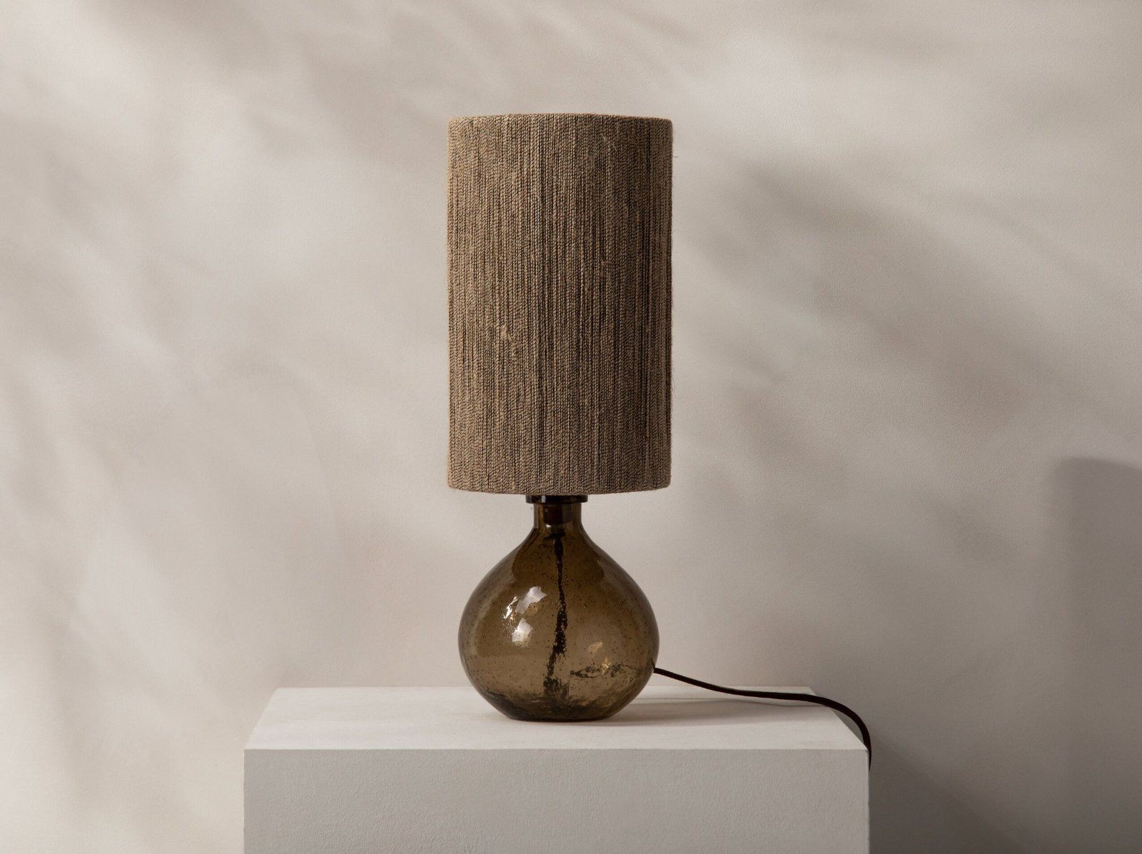 Micadoni Aura Tischleuchte 46 cm Rauchglas – Auf hellem Podest mit braunem Stromkabel