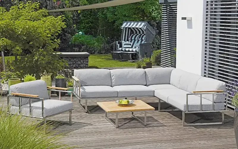 Helle Gartenlounge mit niedrigem Tisch auf einer Holzterrasse im Grünen – SonnenPartner